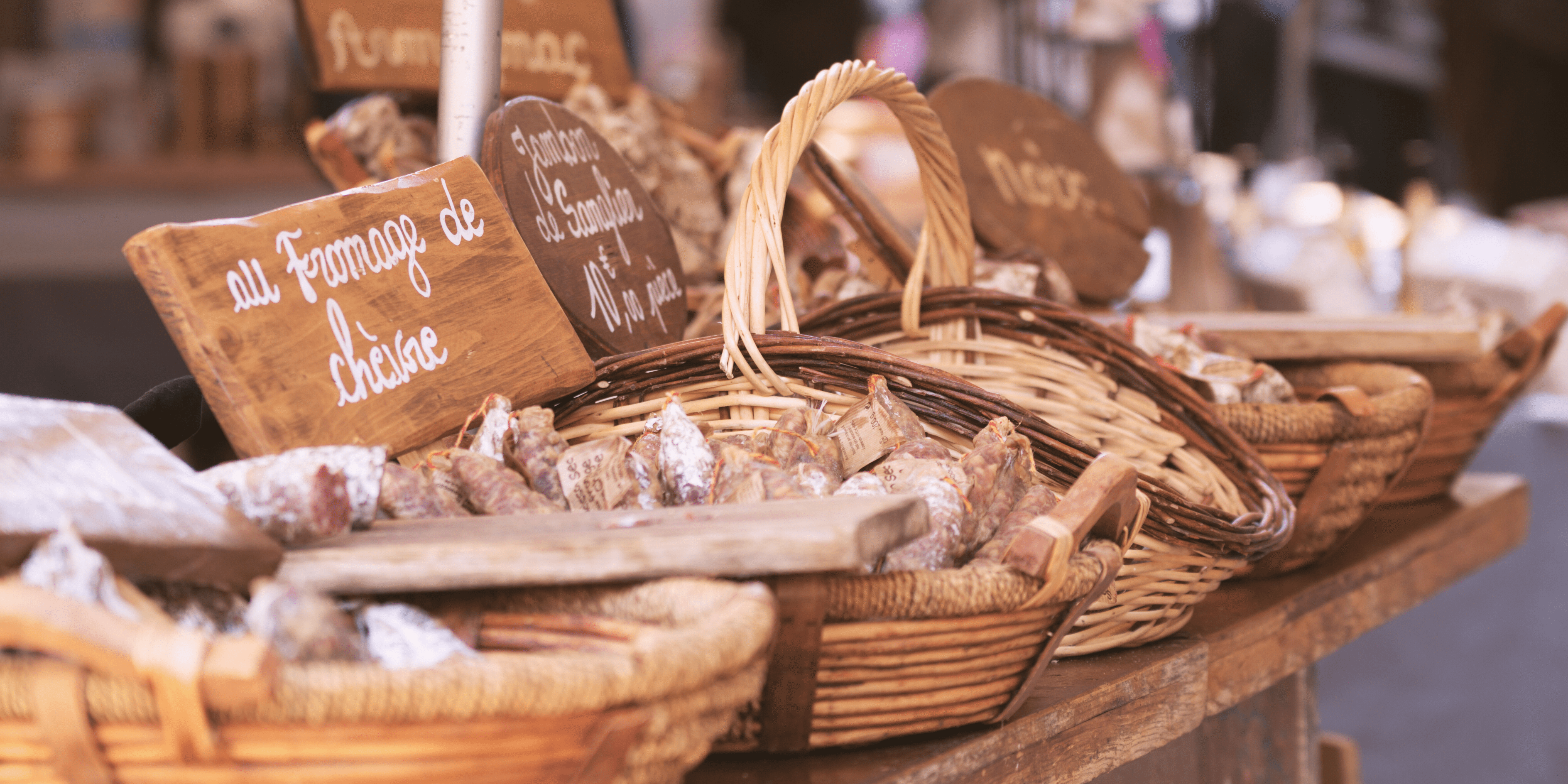 Close-up of a French market stand with a variety of dried sausages on display